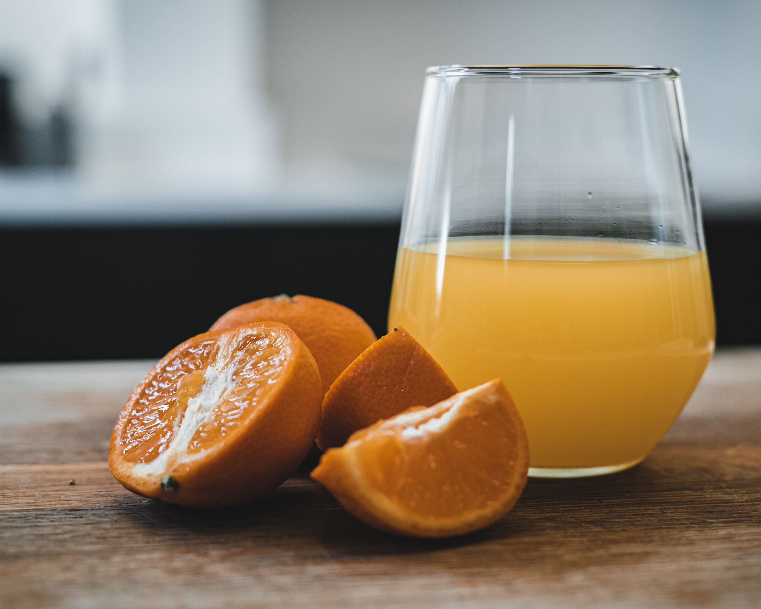 Foods That Spike Blood Sugar After 55 (What to Avoid) glass of orange juice next to a whole orange — fruit juice spikes blood sugar
