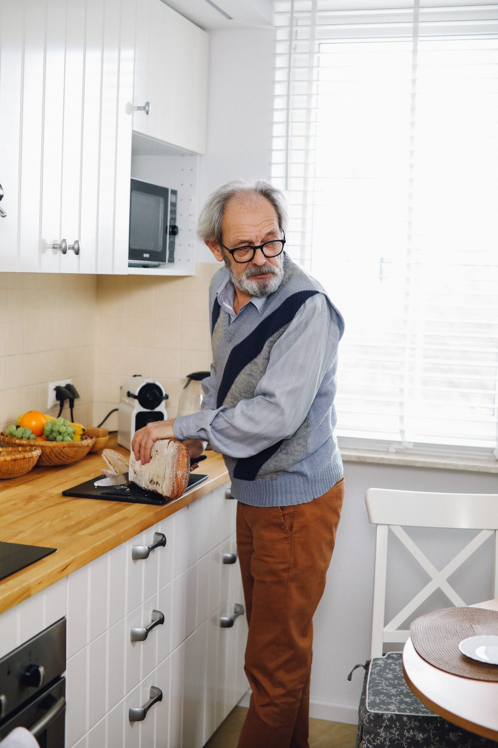Foods That Spike Blood Sugar After 55 (What to Avoid) older man looking at bread — foods that spike blood sugar after 55