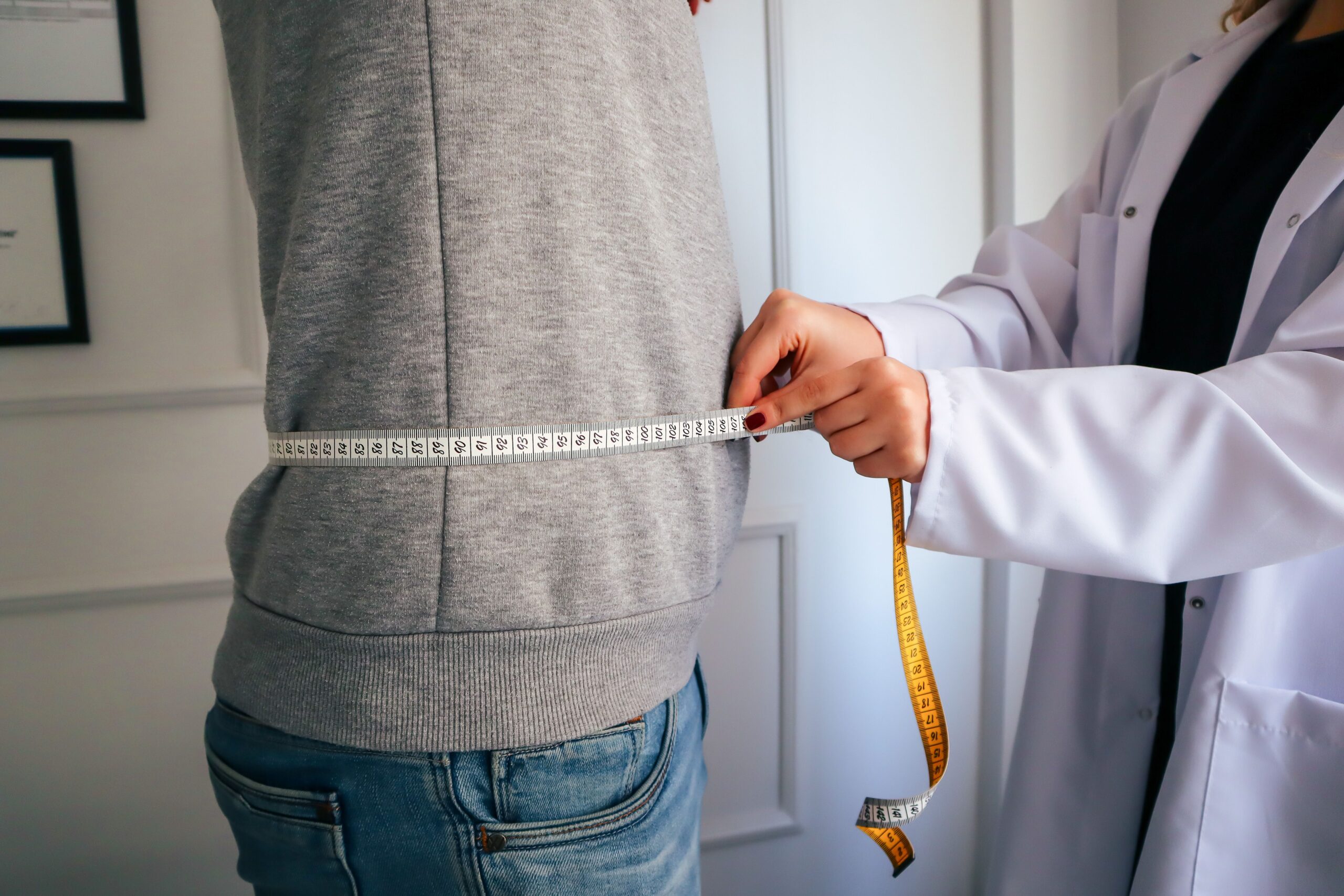 Older adult measuring waist circumference — better than scales for tracking insulin resistance progress
